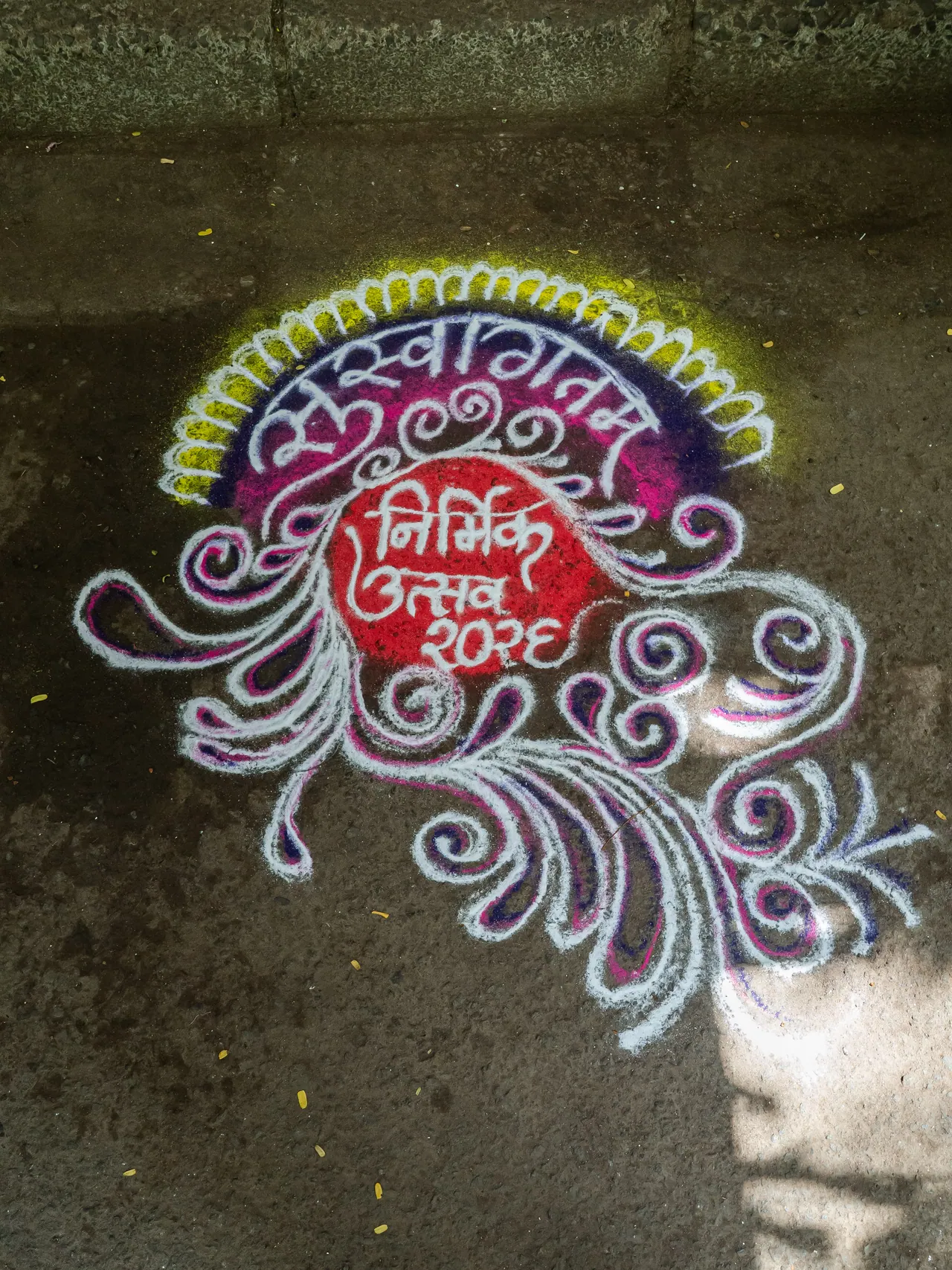 A rangoli drawn on the street reading Nirmik Utsav 2025.
